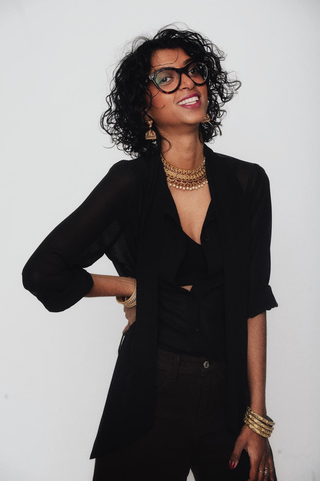 Portrait of a smiling woman with warm skin tones and elegant styling in a soft-lit professional studio setting